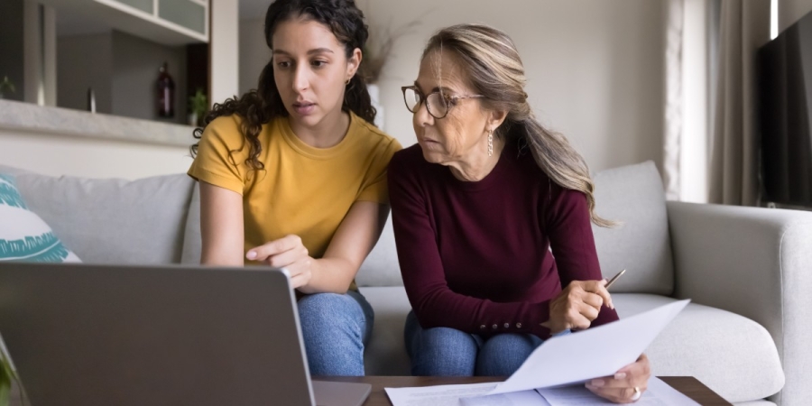 A daughter helping her mother pay a bill online